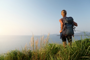 road trip with backpack relaxing on a green meadow and enjoying suns